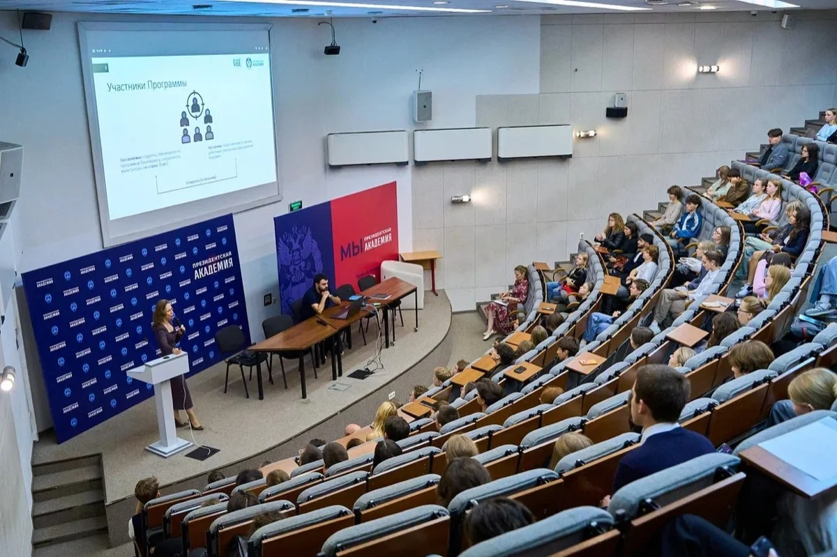 Установочное мероприятие «Научного кода»: слайд об участниках программы и зал слушателей
